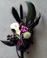 minimal gothic alternative bouquet, black feathers and branches with small flowers and an animal skull