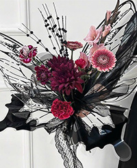 minimal pink and red coloured bouquet wrapped in butterfly shaped and printed plastic