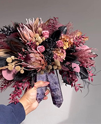 pink and burgundy bouquet with native plants, held by one female hand on crystal wand stem
